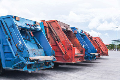 Several cars parked garbage truck for transport to garbage colle